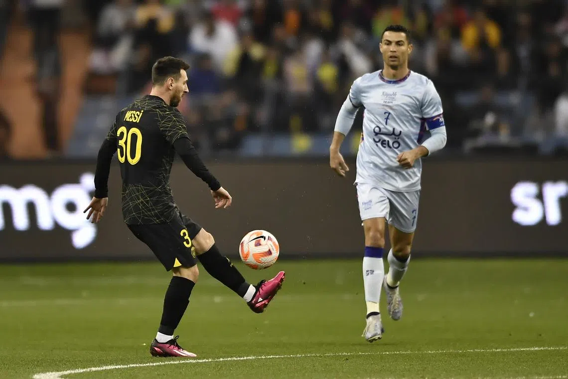 PSG's Lionel Messi (left) in action against Cristiano Ronaldo, during the friendly soccer match between Paris Saint-Germain and the Riyadh Season Team, in  Saudi Arabia.