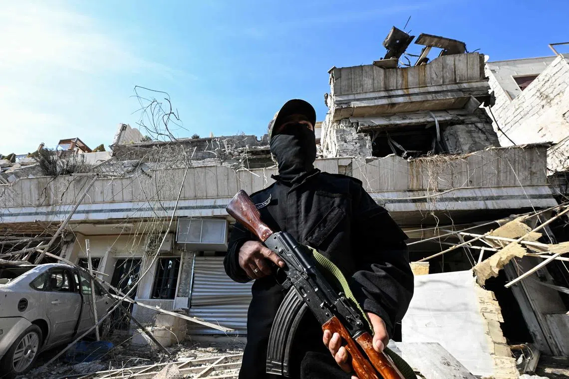 A member of the Syrian security forces standing guard at the site of an Israeli air strike on a building in Damascus in an area where Palestinian leaders are known to reside, on Mar 13, 2025. 