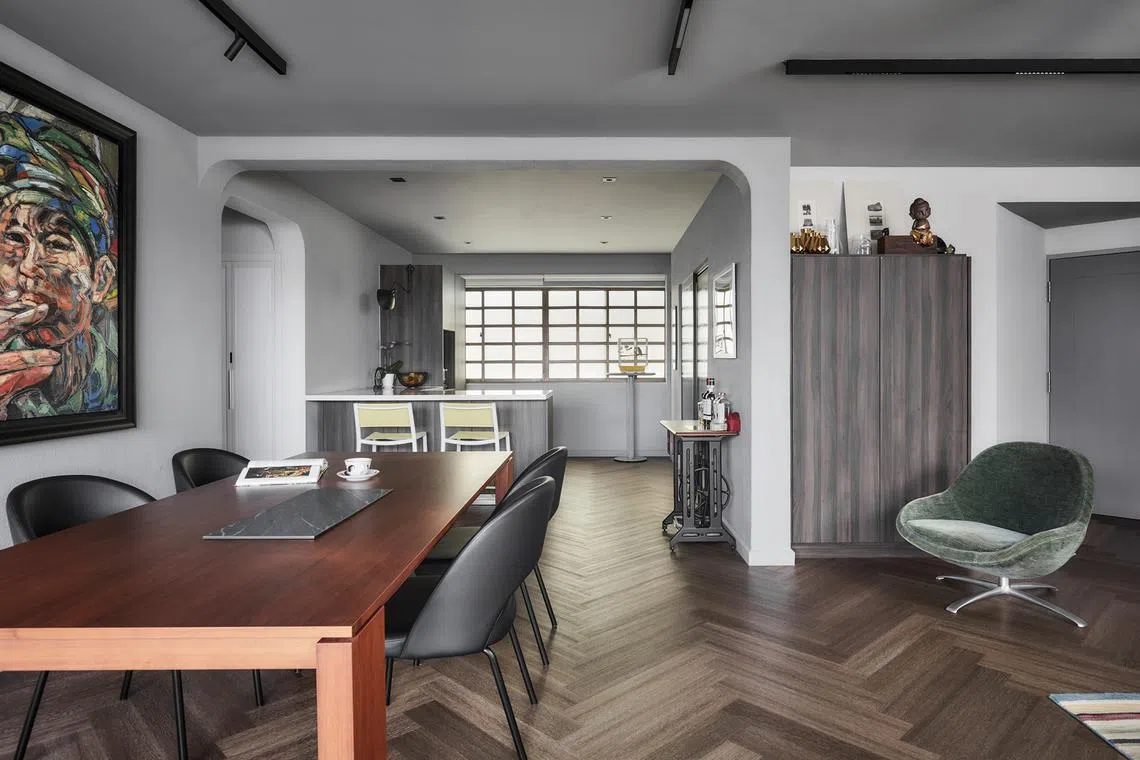 The living and dining area in this Marine Parade home has been decorated with pieces such as a BoConcept moss-green armchair and an eight-seater solid wood dining table.