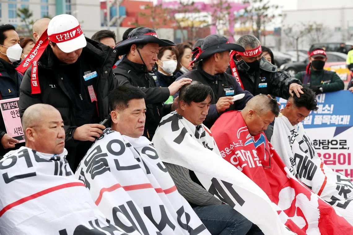 Unionised truck drivers have their hair shaved at a head-shaving protest in Incheon, on Nov 29, 2022.
