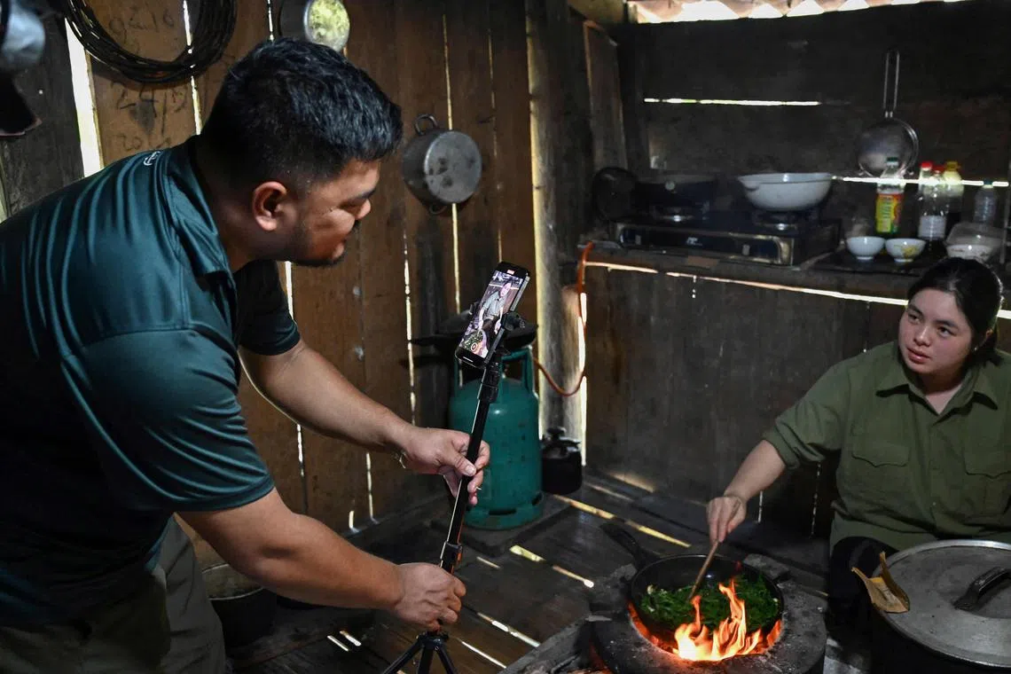 Farmer Luong Quang Dai shoots a video of his wife cooking. He has some 420,000 followers on his TikTok page.