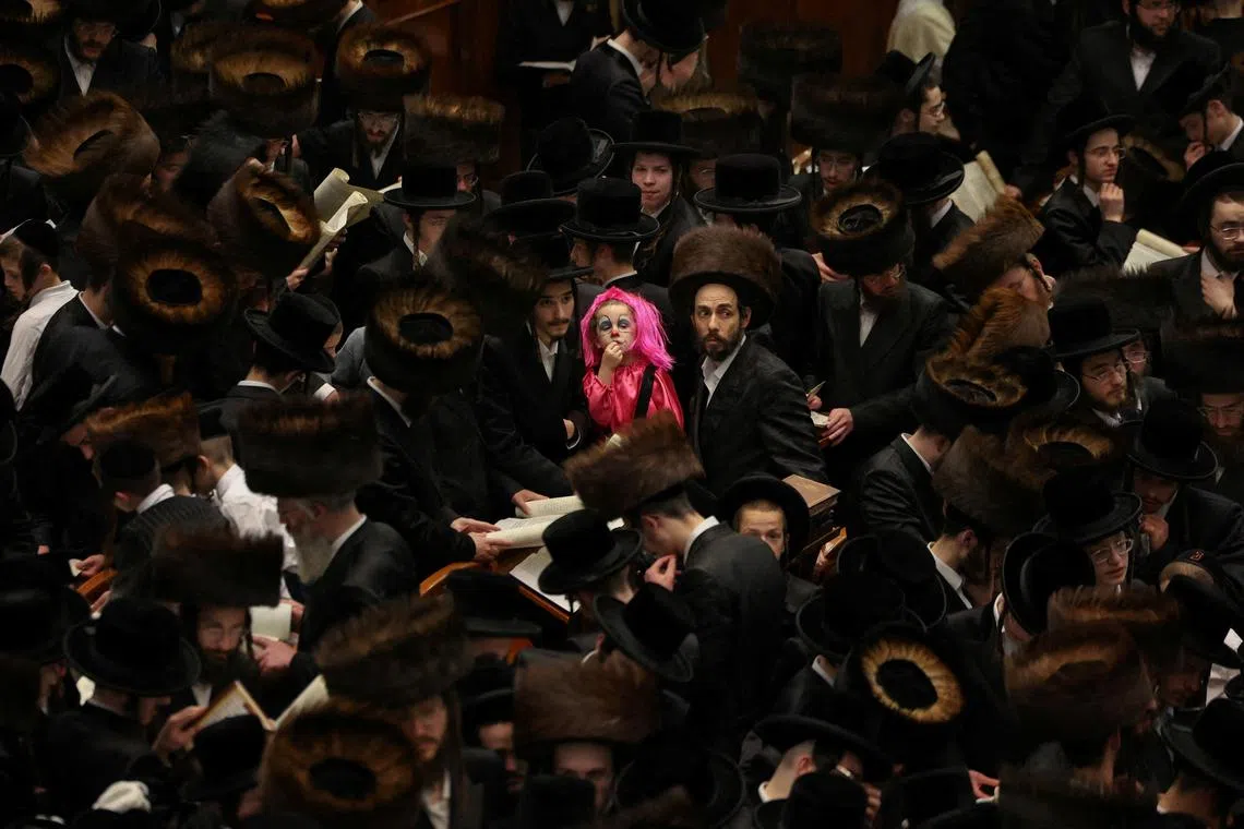 An Ultra-Orthodox Jewish boy from the Belz Hasidic dynasty, dressed in a Purim costume, taking part in the reading from the Book of Esther ceremony performed on the Jewish holiday of Purim, in Jerusalem, on Mar 13, 2025.
