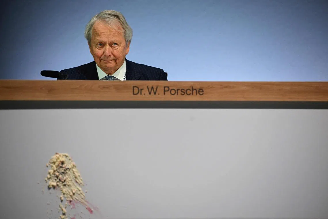 Wolfgang Porsche, board member of German car giant Volkswagen (VW) loos on after a piece of cake has been thrown at the front of his desk during Volkswagen's annual general meeting on May 10, 2023 in Berlin. (Photo by Tobias SCHWARZ / AFP)