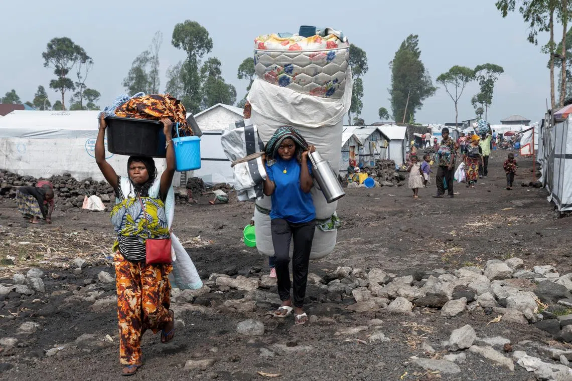Civilians carry their belongings as they flee from the Nzulo camp for the internally displaced to Goma, as fighting intensifies between the M23 rebels and the Armed Forces of the Democratic Republic of the Congo (FARDC), near Goma, Democratic Republic of Congo January 22, 2025. REUTERS/Arlette Bashizi