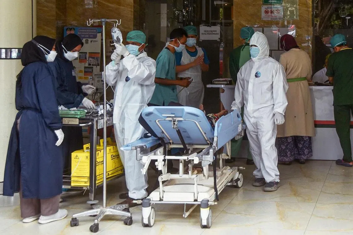 Medical personnel examine a patient in a public hospital near Bekasi, east of Jakarta, on Feb 3, 2022.