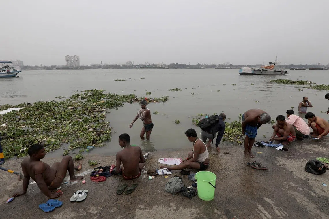 People take a dip near floating plastic and other waste at river Ganges in Kolkata, Eastern India, March 7, 2024. The National Green Tribunal (NGT) a judicial body issued a warning after finding the entire stretch of the Ganga River in the state unfit for bathing due to high levels of faecal coliform bacteria.
