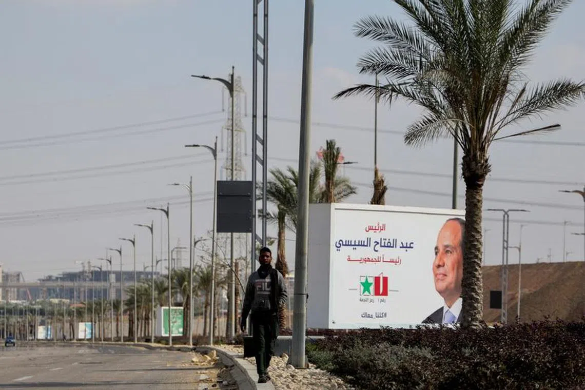 An Egyptian man walks next to a banner of presidential candidate and current Egyptian President Abdel Fattah al-Sisi next to the construction site of a monorail line at the New Administrative Capital (NAC) in the desert east of Cairo, Egypt December 8, 2023. REUTERS/Amr Abdallah Dalsh/File Photo