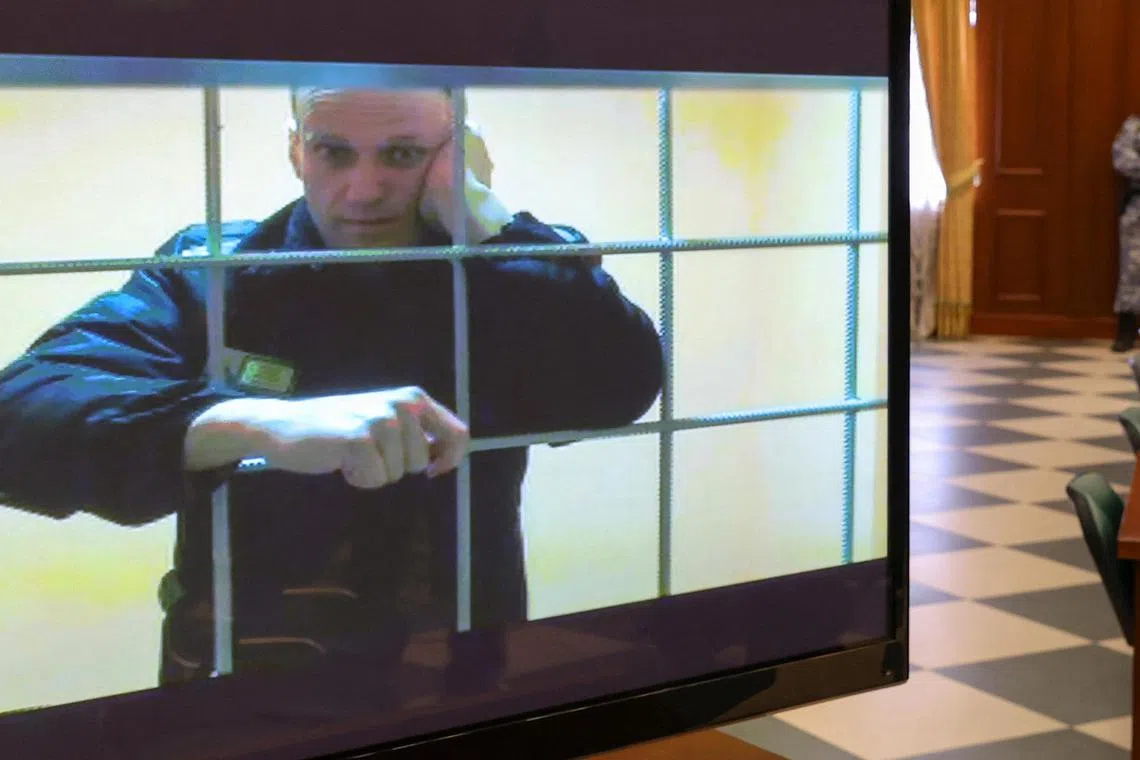 Imprisoned Alexei Navalny (onscreen) says Wagner founder Yevgeny Prigozhin offered convicts a pardon if they survived six months with his private military company.