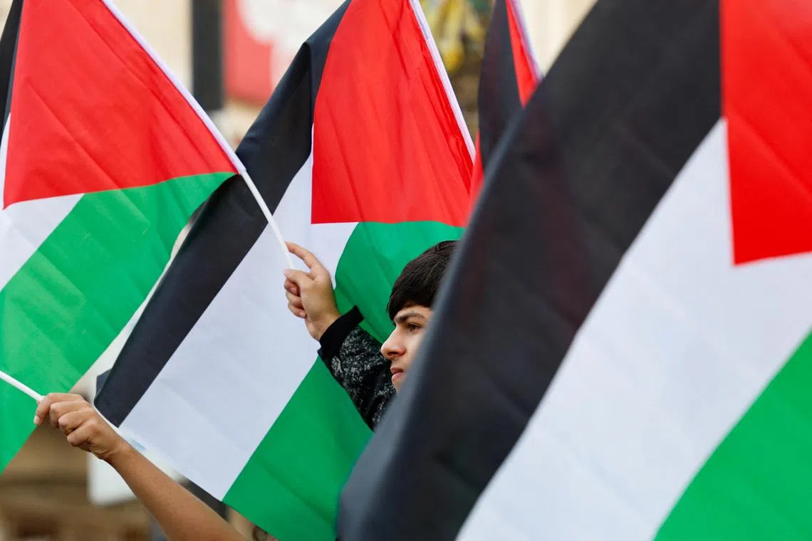 People hold Palestinian flags during a demonstration to demand the release of Palestinians held in Israeli prisons, in Ramallah, in the Israeli-occupied West Bank November 14, 2023. REUTERS/James Oatway/File Photo