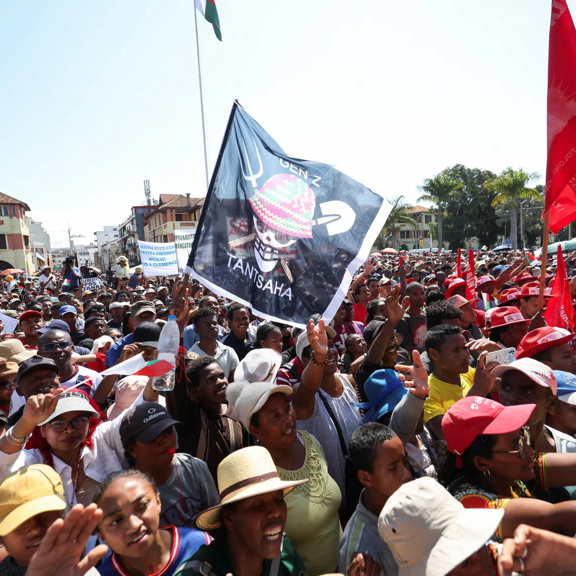A person joins others holding a flag featuring a Malagasy version of the logo from the popular Japanese manga One Piece, a symbol adopted by Gen Z protest movements worldwide, during a gathering along Independence Avenue, following the swearing-in of Colonel Michael Randrianirina as president the previous day, after youth-led protests ousted his predecessor, in Antananarivo, Madagascar, October 18, 2025. REUTERS/Siphiwe Sibeko
