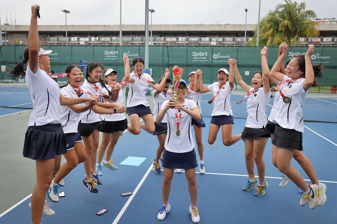 Methodist Girls' School (MGS)' tennis team celebrating with their B Division girls' trophy after defeating Raffles Girls' School on Mar 4.