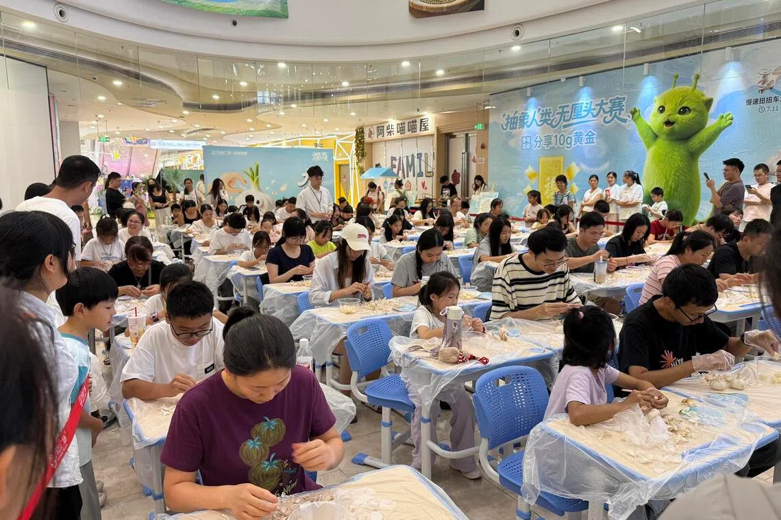 People participate in a garlic peeling contest at the Longgang Wanda Plaza in Shenzhen on Aug 8.