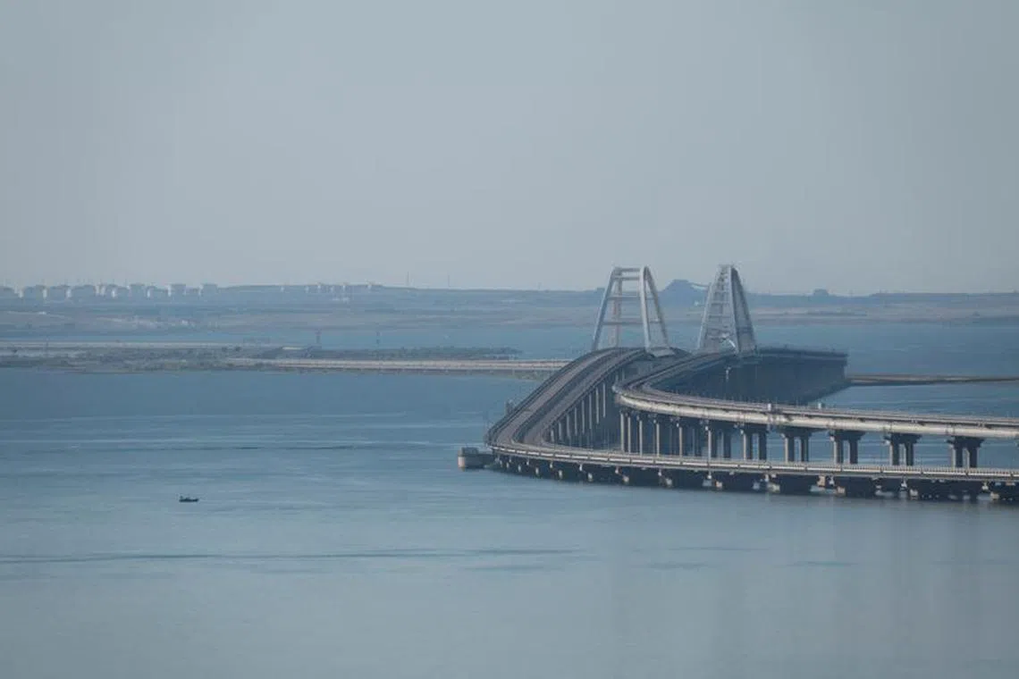FILE PHOTO: A boat sails next to the Crimean bridge connecting the Russian mainland with the peninsula across the Kerch Strait, Crimea, July 17, 2023.  REUTERS/Stringer/File Photo