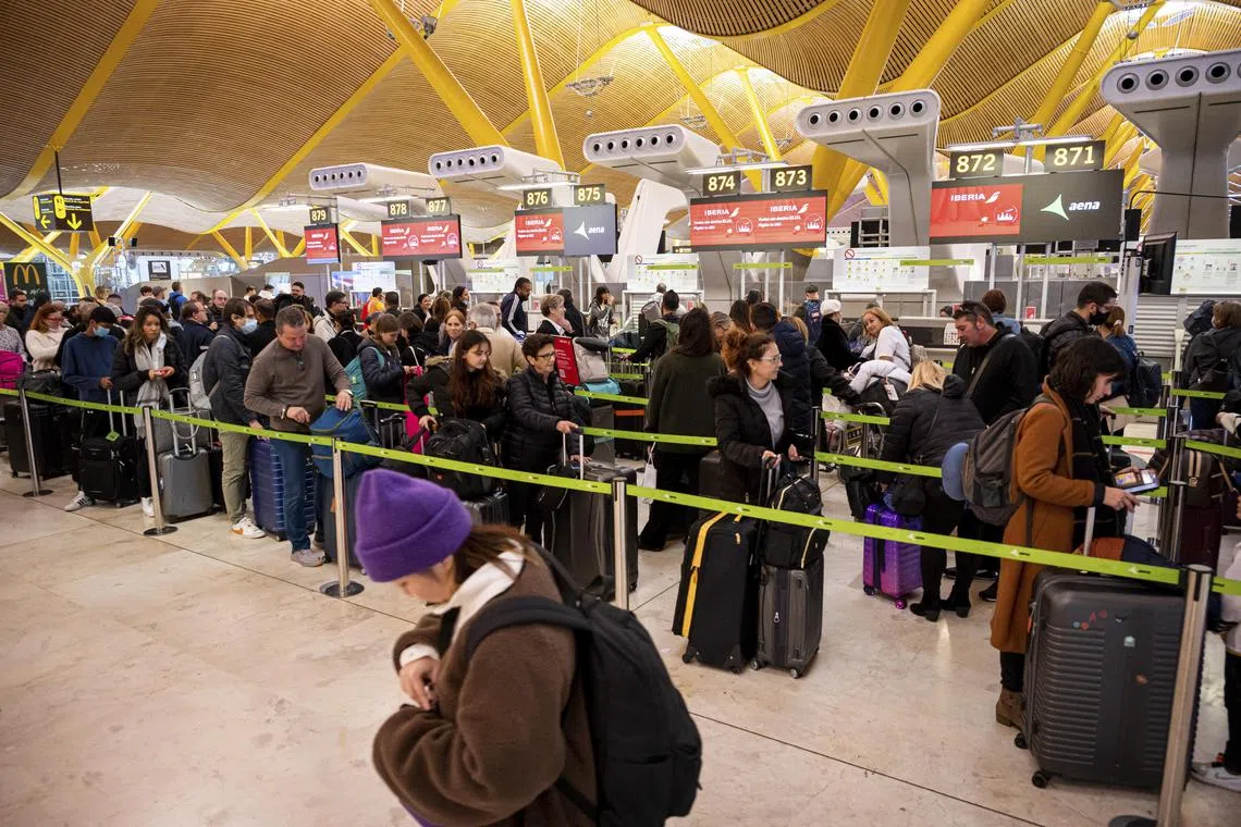 epa10382646 Travelers stand in a line at Barajas airport in Madrid, Spain, 30 December 2022. The Spanish Government has decided to reinforce controls at Spanish airports and will require passengers arriving from China to have a negative test for Covid-19 or a complete vaccination schedule.  EPA-EFE/FERNANDO VILLAR