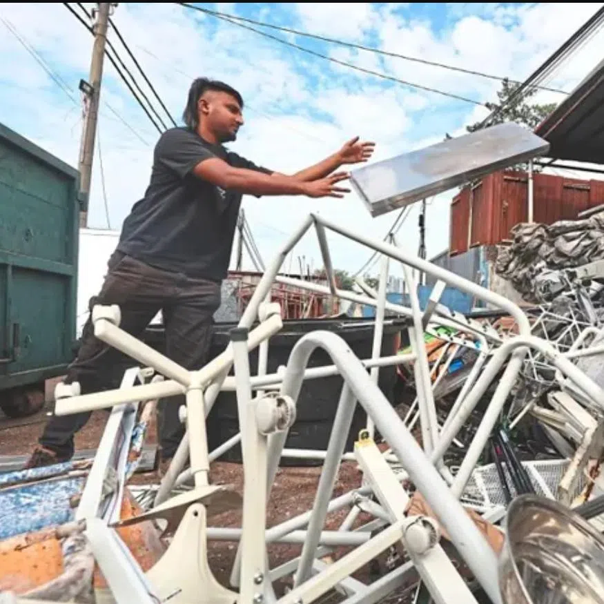  A worker from Nithia Sree Enterprise, a licensed operator in Kg Sg Kayu Ara, sorting out metallic items for recycling.