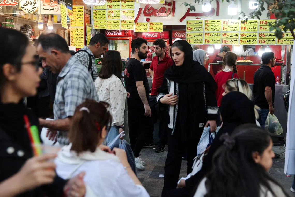 FILE PHOTO: Iranian people walk at the Tehran Bazaar after the approval of the bill to remove four zeros from the national currency, in Tehran, Iran, October 5, 2025. Majid Asgaripour/WANA (West Asia News Agency) via REUTERS/File Photo