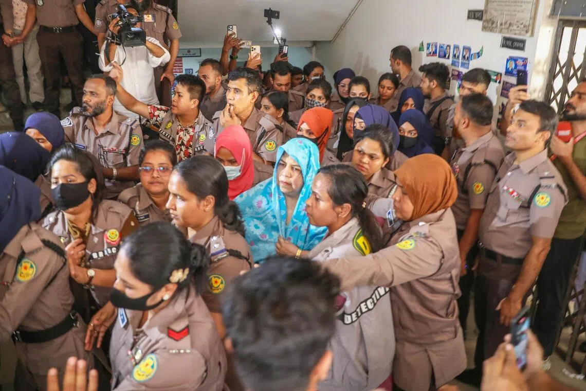 Bangladesh police officers stand guard as former speaker Shirin Sharmain Chowdhury (centre) is escorted to the Chief Metropolitan Magistrate (CMM) Court in Dhaka, Bangladesh on April 7, 2026. 