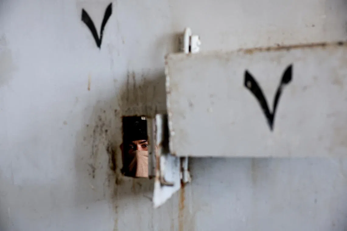 Hayat al-Turki, 27, looks on inside Sednaya prison, which was known as a slaughterhouse under Syria's Bashar al-Assad rule, hoping to find her relatives, after rebels seized the capital and announced that they have ousted Syria's Bashar al-Assad, in Sednaya, Syria, December 11, 2024. REUTERS/Ammar Awad