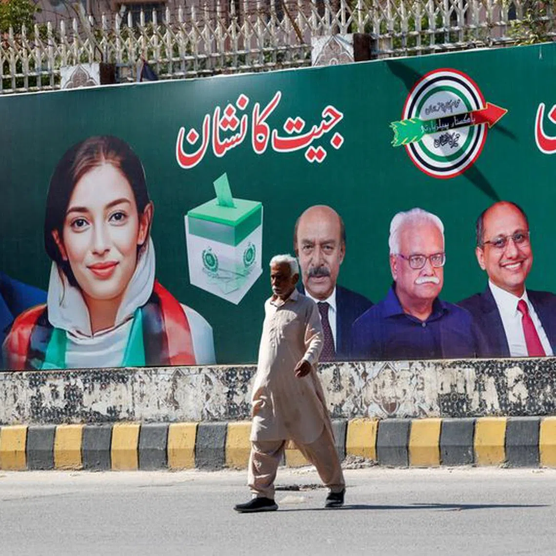 FILE PHOTO: A man walks next to a billboard displaying photos of politician Bilawal Bhutto and his sister Asifa Bhutto, a day after general elections in Karachi, Pakistan February 9, 2024. REUTERS/Akhtar Soomro/File Photo