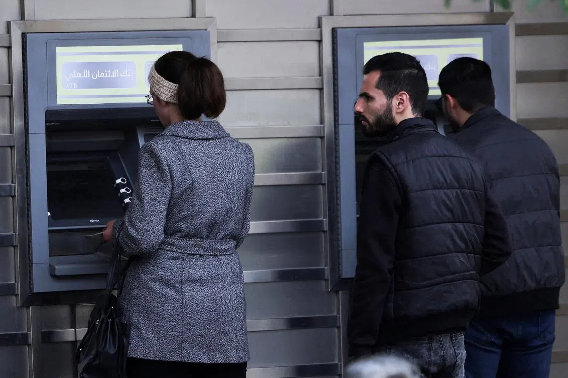 FILE PHOTO: People wait in front of ATM machine, after rebels seized the capital and ousted Syria's Bashar al-Assad, in Damascus, Syria December 11, 2024. REUTERS/Amr Abdallah Dalsh/File Photo