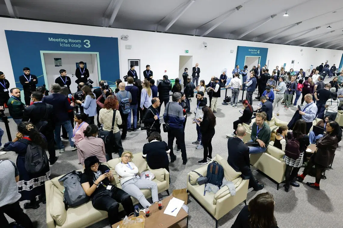 People gather outside the negotiation room during the COP29 United Nations Climate Change Conference, in Baku, on Nov 23.