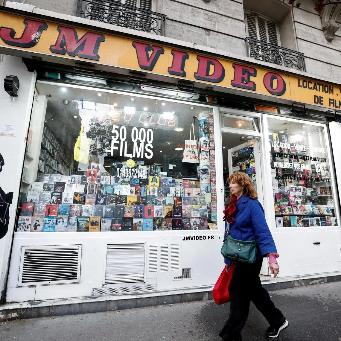FILE PHOTO: A pedestrian walks past JM Video, a video rental store, which is facing financial difficulties, in Paris, France, September 13, 2025. REUTERS/Benoit Tessier/File Photo