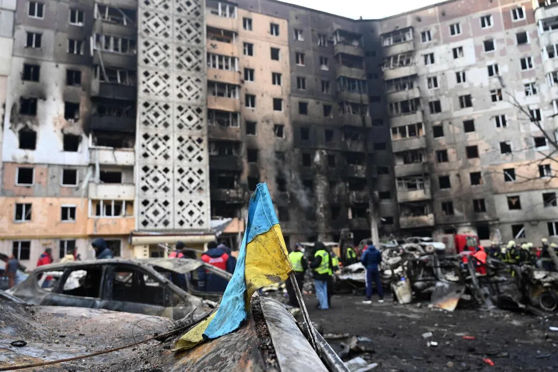 A Ukrainian flag is seen attached to a burned car at the site of a heavily damaged residential building in Ternopil, Ukraine, on Nov 19, following a Russian attack.