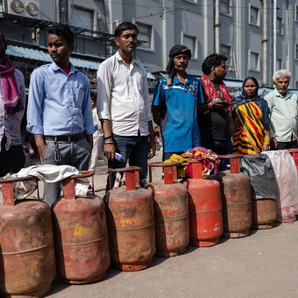 Buyers queue for liquefied petroleum gas (LPG) at a depot in Noida, Uttar Pradesh, on March 16.