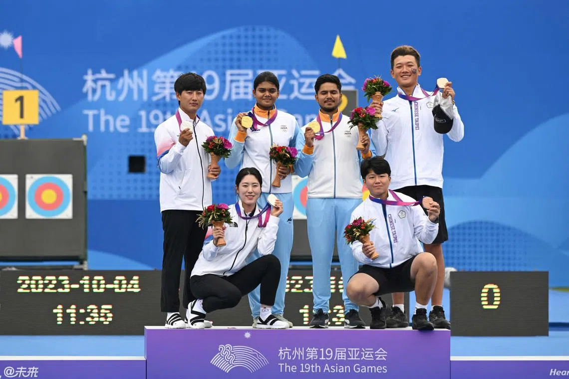 Archers from India, South Korea and Chinese Taipei pose for photographs during the medal ceremony following the mixed team compound event at the Asian Games.