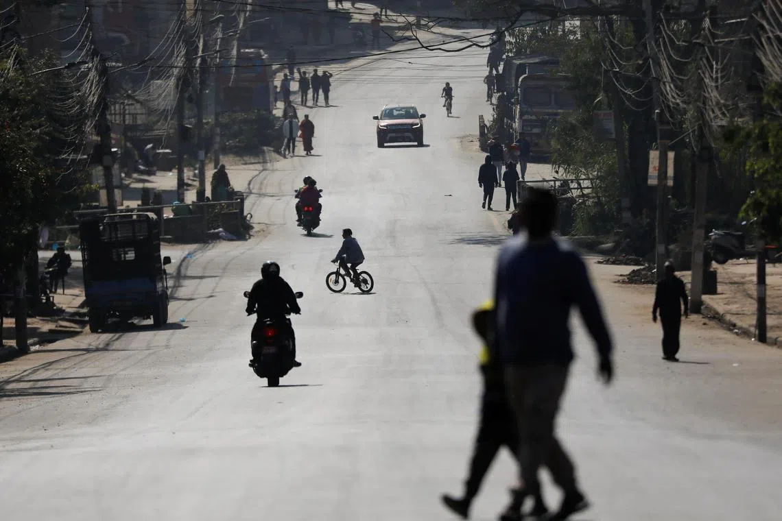 People walk along a road in Bhaktapur, Nepal, on Nov 20, 2022.