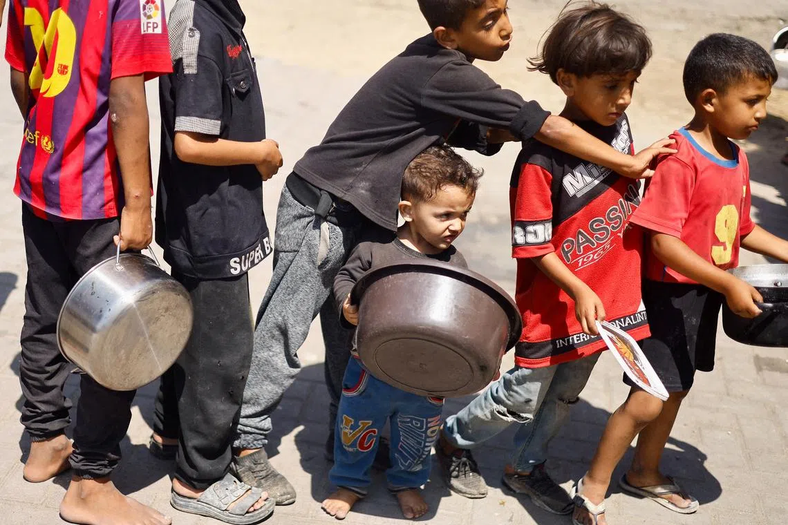 FILE PHOTO: Palestinian children gather to receive food cooked by a charity kitchen, amid food scarcity, as Israel-Hamas conflict continues, in Khan Younis in the southern Gaza Strip, June 26, 2024. REUTERS/Mohammed Salem/File Photo