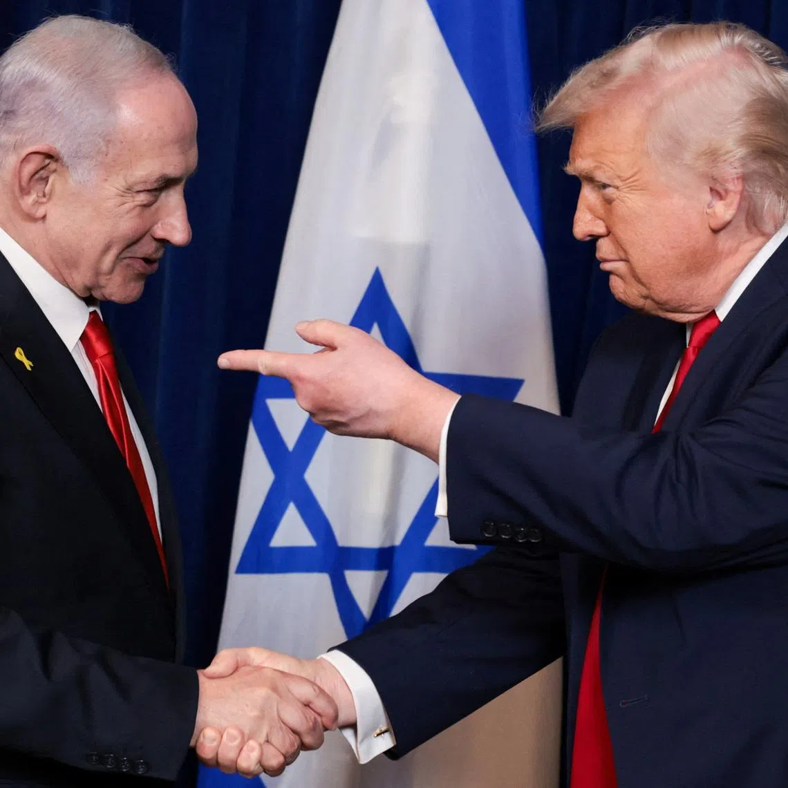 U.S. President Donald Trump points his finger towards Israeli Prime Minister Benjamin Netanyahu as they shake hands during a press conference after meeting at Trump’s Mar-a-Lago club in Palm Beach, Florida, U.S., December 29, 2025. REUTERS/Jonathan Ernst