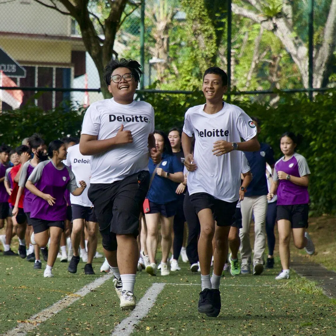 NorthLight students Muhamad Shazali Juma’at (front, left) and Mohamed Ali Khan Borhan (front, right), both 15, leading students and staff from the school in a run at the school on Aug 14, 2025. Both Year 3 students are taking part in Deloitte’s 6000 for 60 fundraising run.
