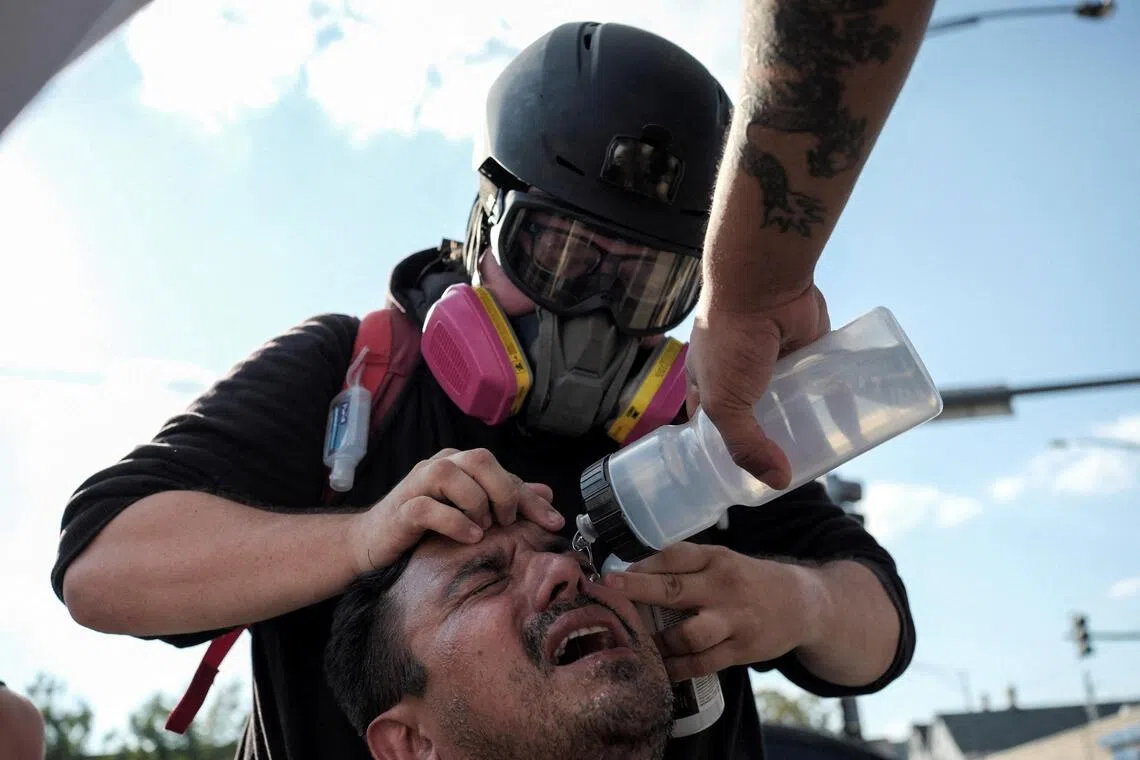 A demonstrator receiving assistance after law enforcement officers used tear gas in the Little Village neighbourhood of Chicago, Illinois, on Oct 4.