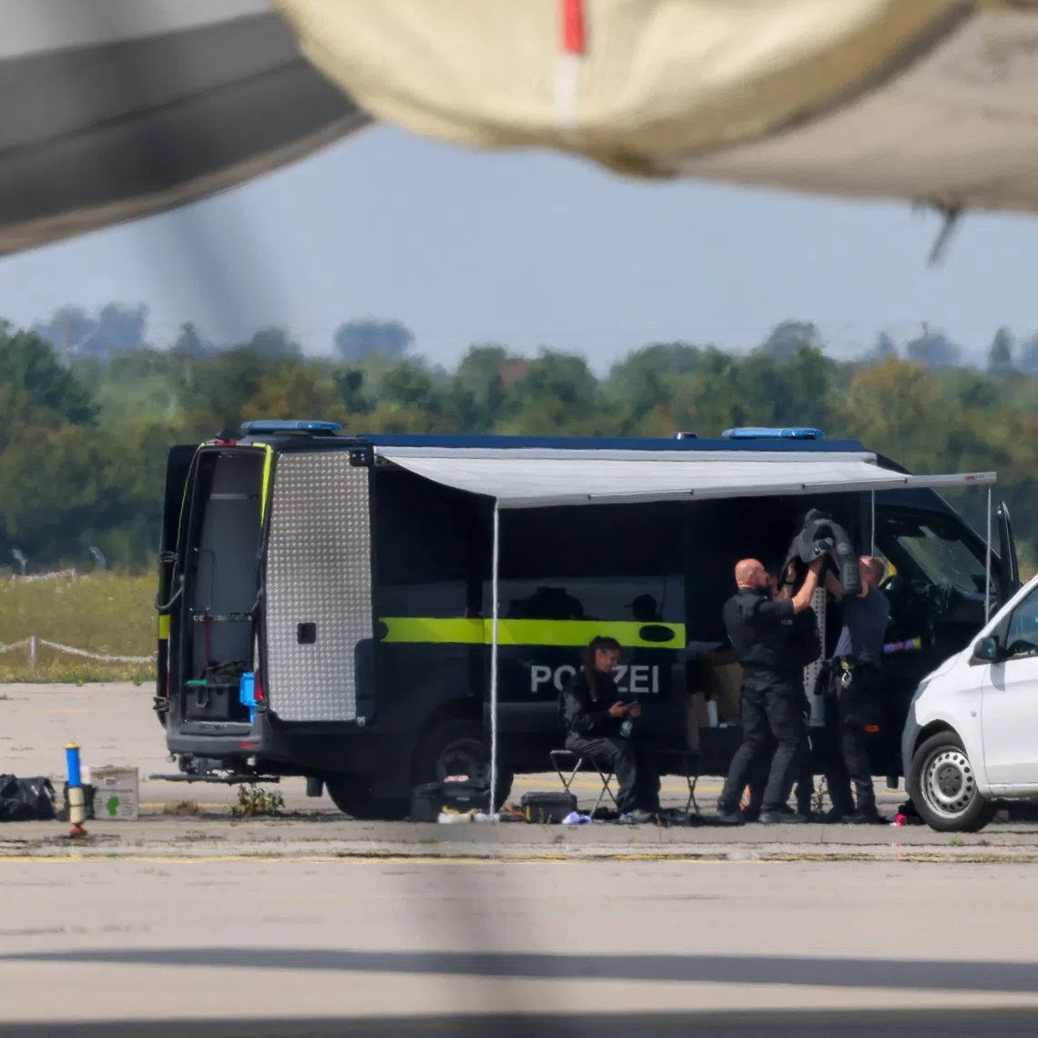 Police officers work in the vicinity of an Antonov cargo plane, near which a drone was found, at Leipzig/Halle Airport in Schkeuditz, Germany, August 5, 2026, after the police said explosives experts examined a drone near a runway, and after a DHL cargo aircraft hit an unknown object as it was climbing away from the airport overnight, prompting an unscheduled landing in Hanover, according to a source familiar with the incident. REUTERS/Axel Schmidt