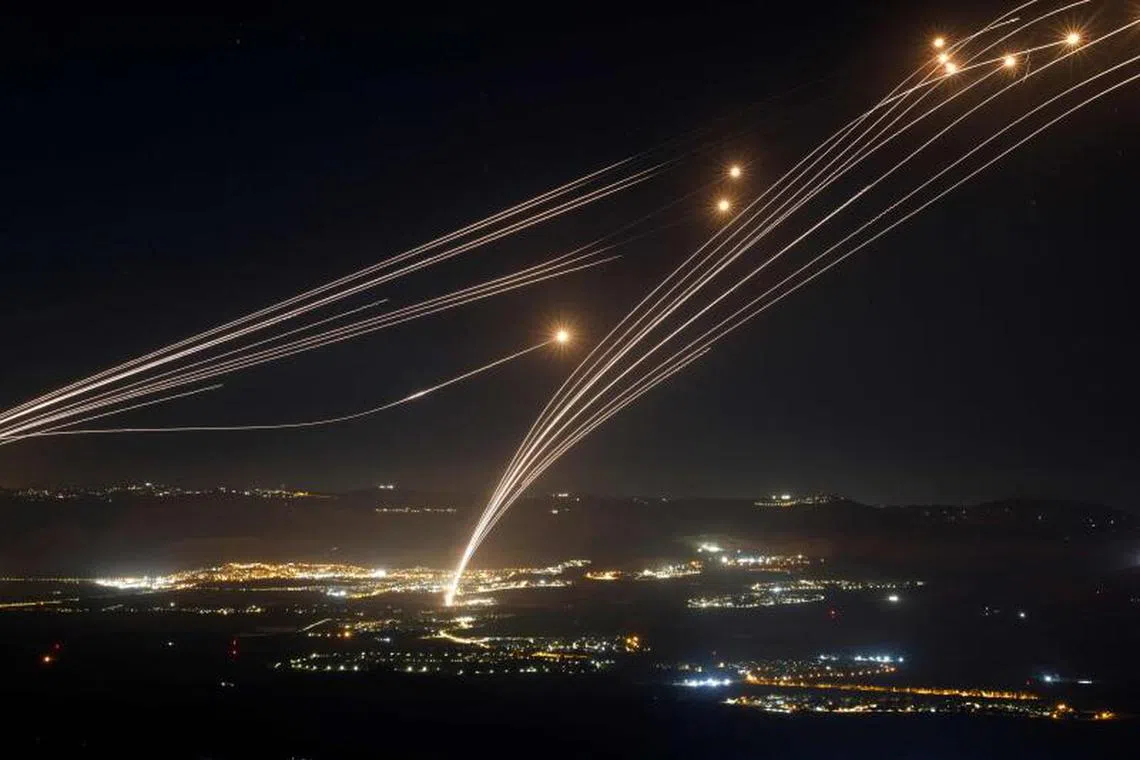-- AFP PICTURES OF THE YEAR 2024 -- Rockets fired from southern Lebanon are intercepted by Israel's Iron Dome air defence system over the Upper Galilee region in northern Israel, on August 4, 2024, amid ongoing cross-border clashes between Israeli troops and Lebanon's Hezbollah fighters.. Middle East tensions soared Saturday as Iran and its allies readied their response to the assassination of Hamas's political leader, blamed on Israel, spurring fears of a regional war. (Photo by Jalaa MAREY / AFP) / AFP PICTURES OF THE YEAR 2024