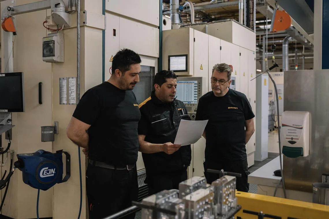 Emrullah Karaca, center, a cutting machine mechanic who began working at Continental when he was in high school, speaks with fellow workers at the factory in Gifhorn, Germany, on April 18, 2024. After spending more than two decades building a career at the factory, Karaca, a 49-year-old father of three, learned that Continental planned to close the plant by 2027. Facing a daunting job hunt, he will head back to school to earn his trade certificate, courtesy of his employer. (Patrick Junker/The New York Times)