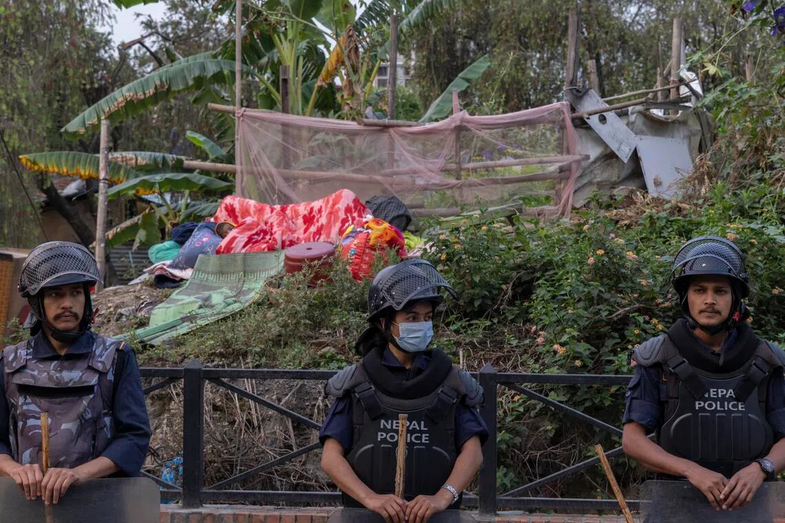 Nepalese police stand guard as the Nepal government begins demolition of riverbank squatter settlements in Kathmandu, Nepal, on April 25.