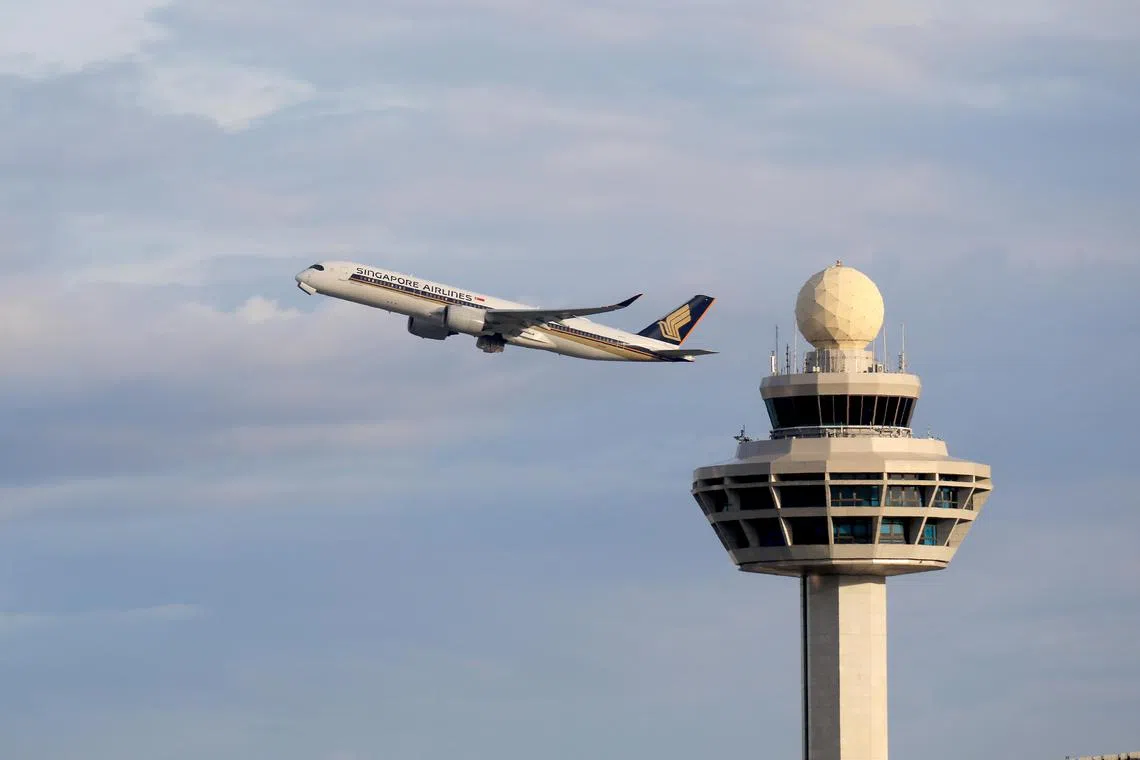 一架新加坡航空客机飞过樟宜机场控制塔。
Caption: 新航 ，旅客，机场，旅客量，入境旅客，旅游，樟宜机场，樟宜机场控制塔, SQ, SIA, ICA, Tourist, Immigration, Changi Airport Control Tower