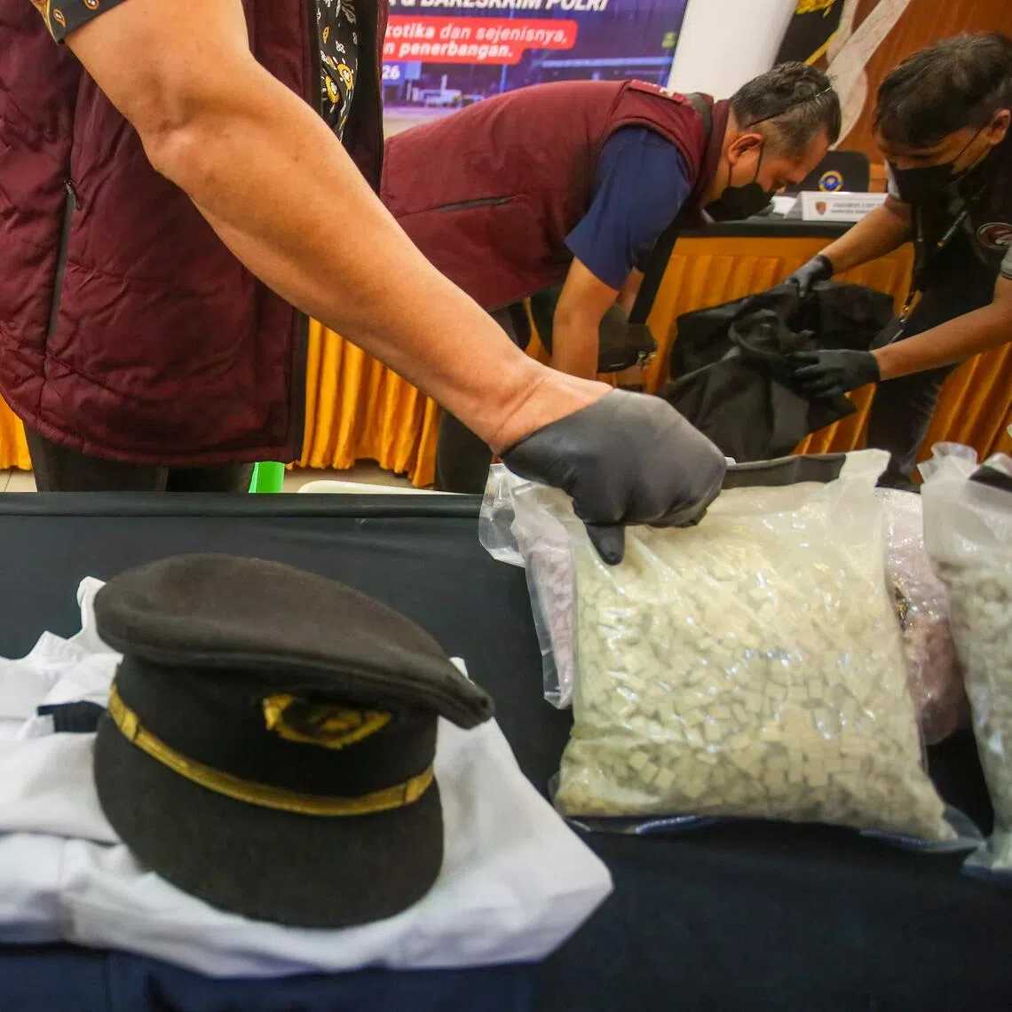 The uniform of a Malaysian pilot and the drugs he tried to smuggle into Indonesia are presented during a news conference in Jakarta.
