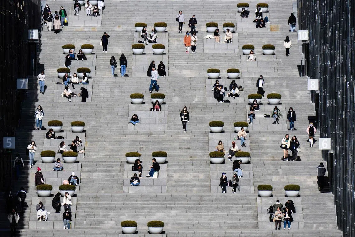 Students and visitors walk around the campus of Ewha Womans University in Seoul on March 2, 2023, which was founded in 1886. (Photo by ANTHONY WALLACE / AFP)