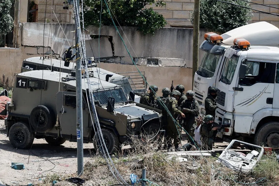 FILE PHOTO: Israeli soldiers detain a Palestinian man during an Israeli raid in Deir al-Ghusun, in the Israeli occupied West Bank, May 4, 2024. REUTERS/Raneen Sawafta/File Photo