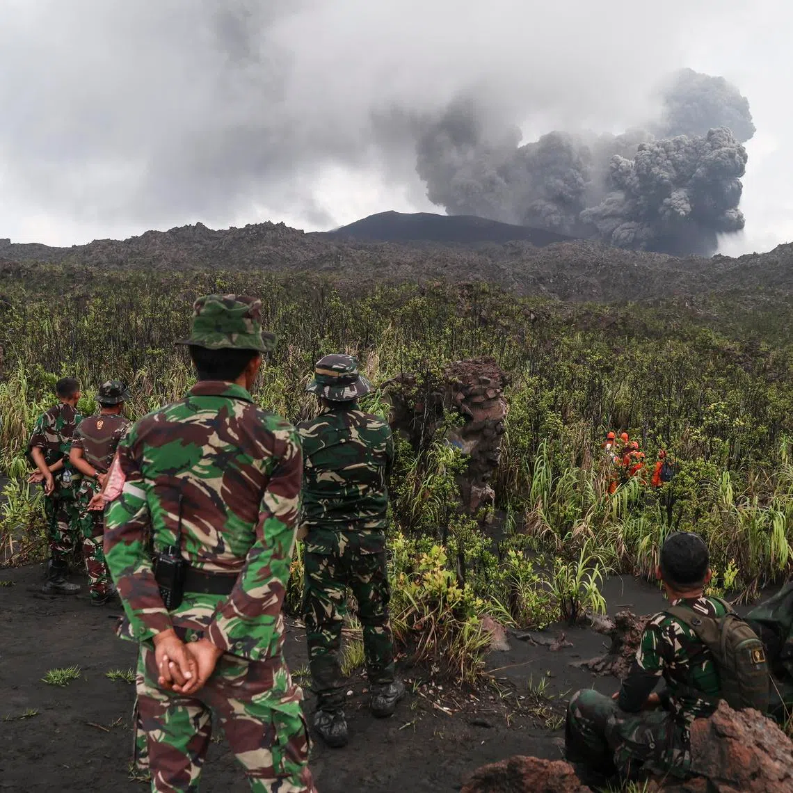 Rescuers look on Mount Dukono volcano during its eruption in North Halmahera, Indonesia, on May 9.