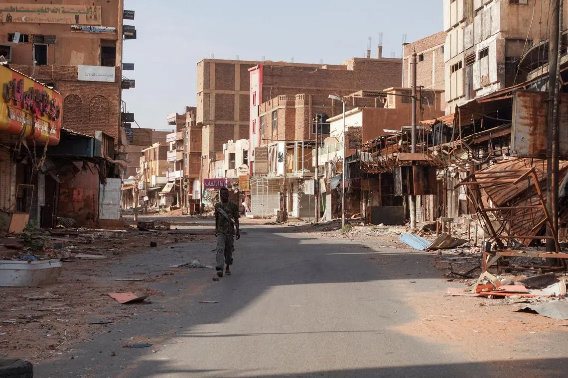 FILE PHOTO: A member of the Sudanese Armed forces walks between damaged buildings, almost one year into the war between the Sudanese Armed Forces and the paramilitary Rapid Support Forces (RSF), in Omdurman, Sudan, April 7, 2024. REUTERS/El Tayeb Siddig/File Photo