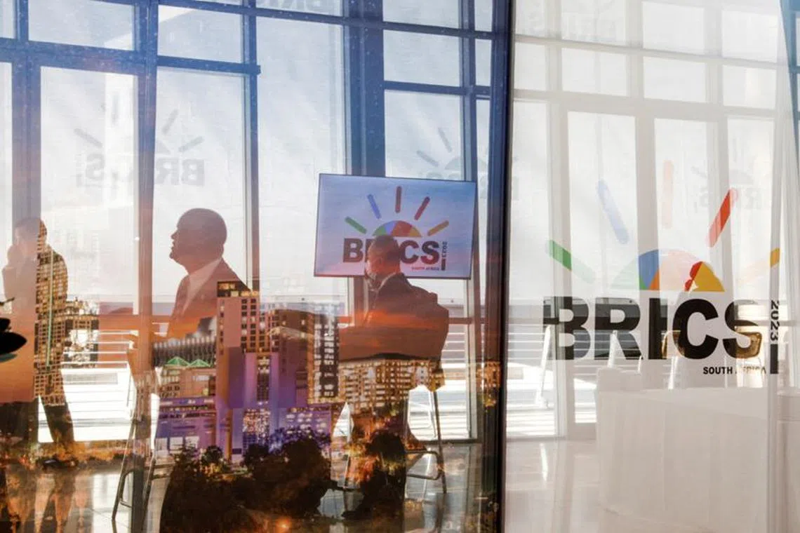FILE PHOTO: Delegates walk past the logos of the BRICS summit during the 2023 BRICS Summit at the Sandton Convention Centre in Johannesburg, South Africa on August 23, 2023. GIANLUIGI GUERCIA/Pool via REUTERS/File Photo