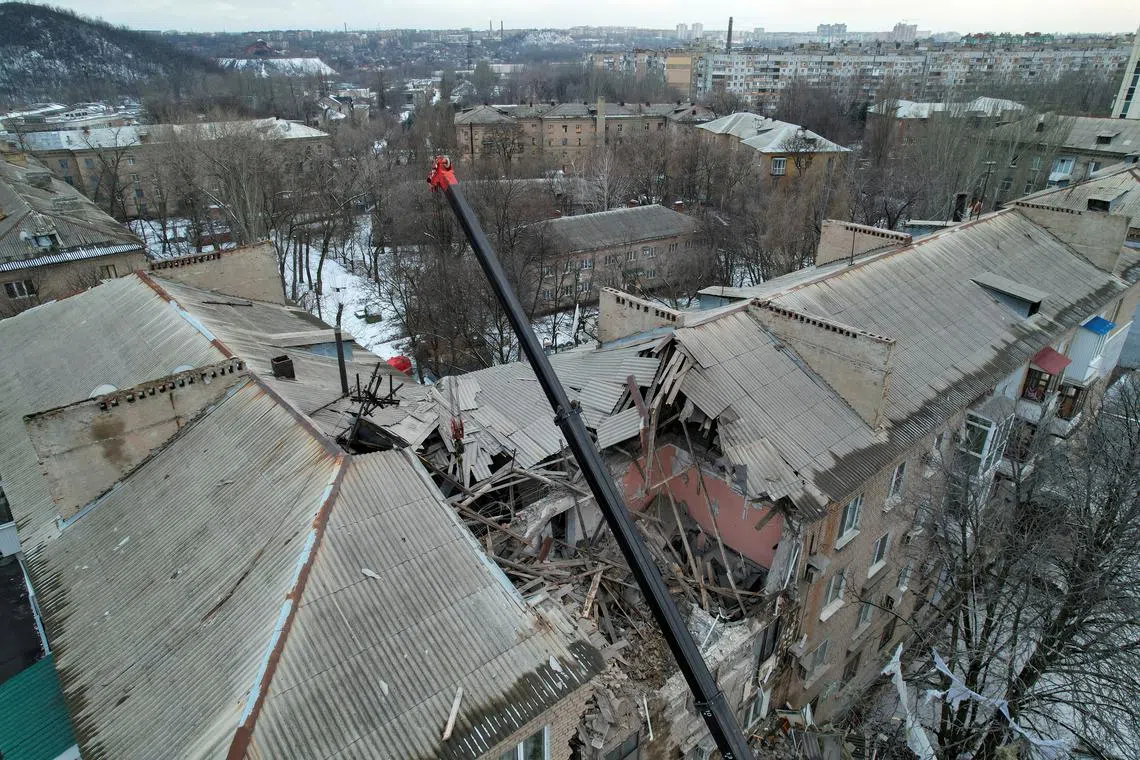 Rescuers use a crane to remove debris of a multistorey residential building in Donetsk, Ukraine, on Feb 4, 2023.