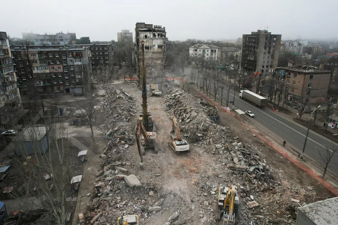 FILE PHOTO: Workers demolish a building, which was destroyed in the course of Russia-Ukraine conflict, in Mariupol, Russian-controlled Ukraine, December 24, 2022. REUTERS/Pavel Klimov/File Photo