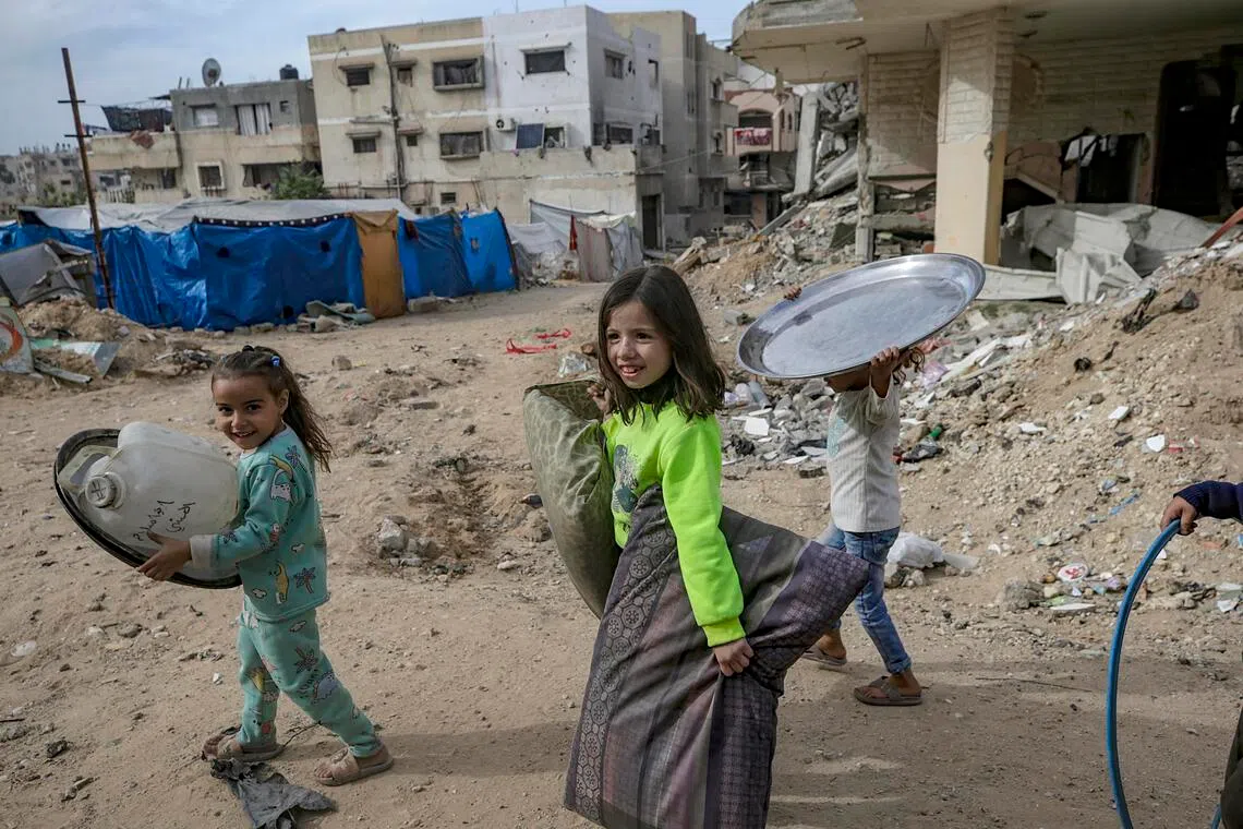 Internally displaced Palestinian children walk among the ruins of destroyed buildings in a neighbourhood in Gaza City.