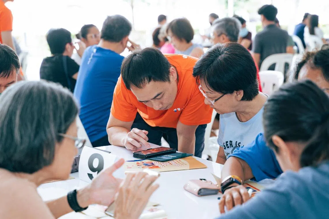 A Shopee volunteer shares with attendees how to use the ecommerce platform at the ShopeeGivesBack event. 