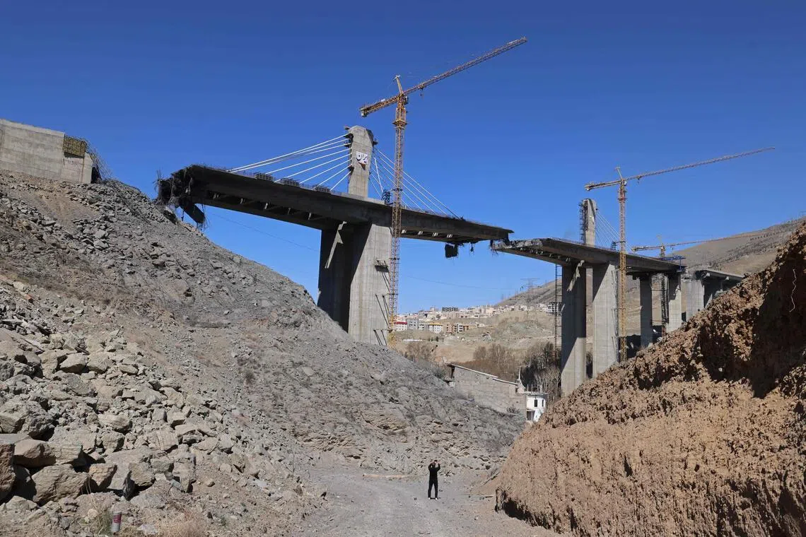 A man takes pictures with his mobile phone of the B1 bridge, a day after it was destroyed by a strike in Karaj, around 35km southwest of Tehran, April 3, 2026. 